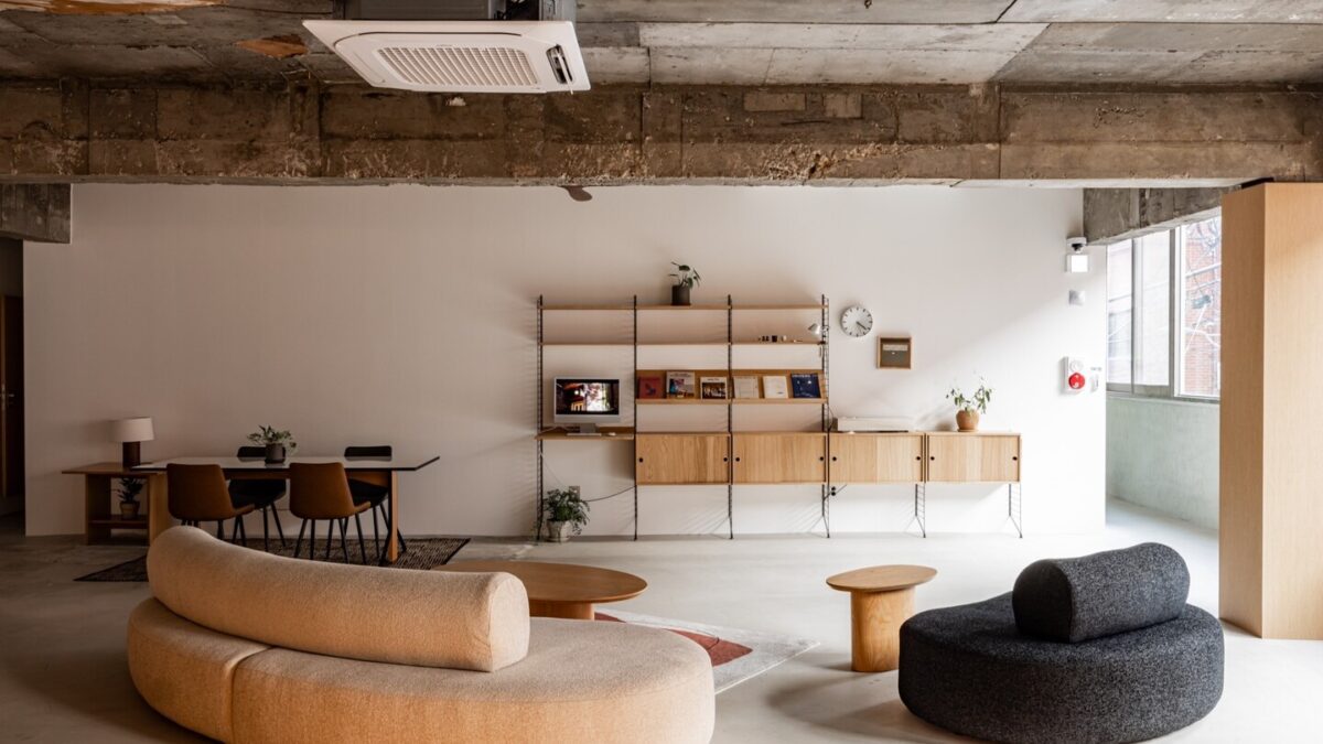 Modernes String Regalsystem mit Büchern und Dekorationsobjekten im skandinavischen Wohnzimmer-Design.
