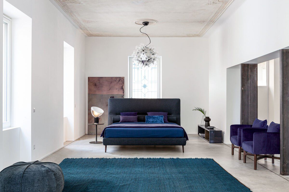 Modernes Twils De Light Bett mit gepolstertem Kopfteil und eleganten Holzbeinen.