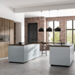 Moderne Rotpunkt-Küche mit Kochinsel, eleganter Holzoptik und schwarzen Griffleisten.