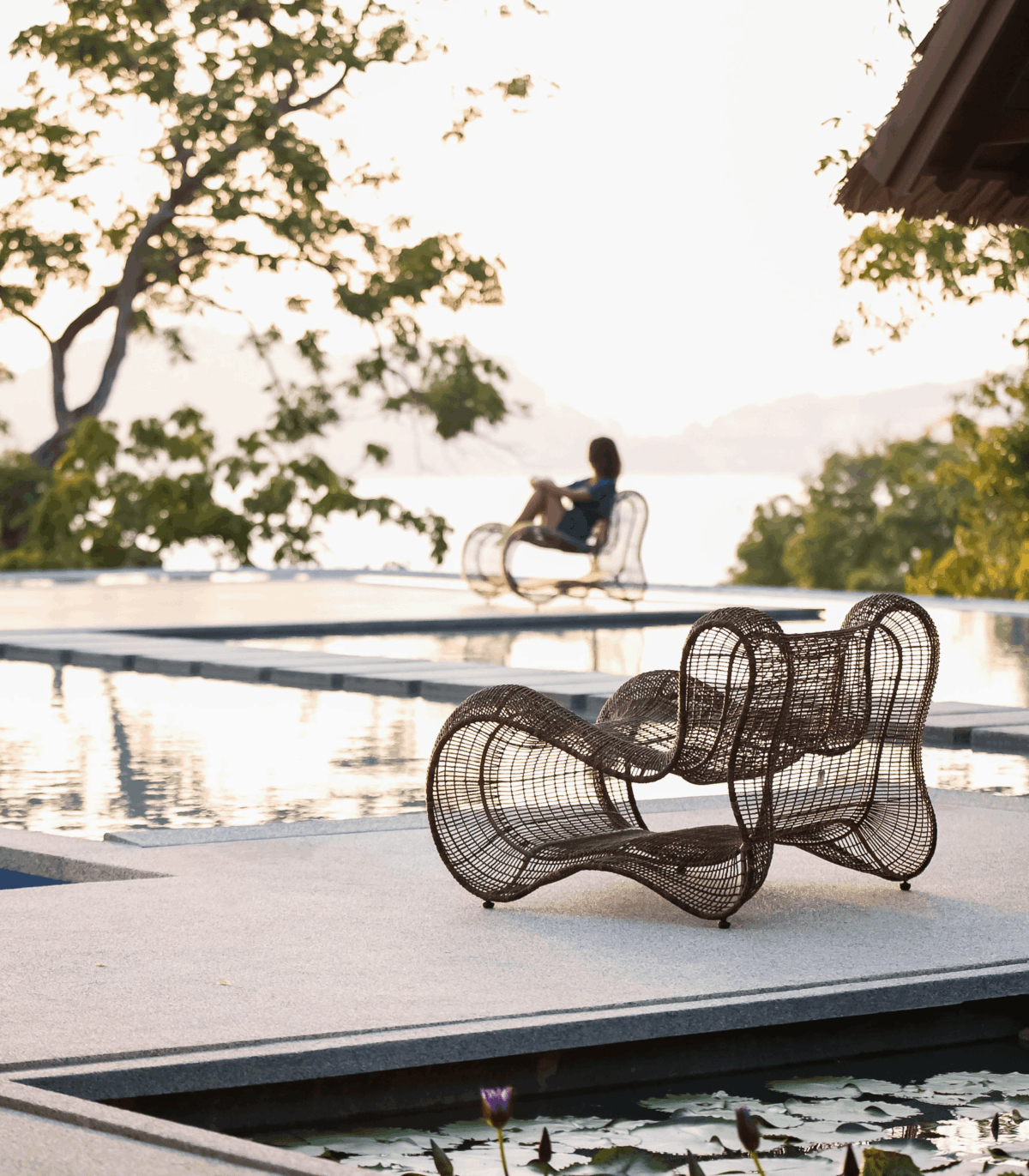 Eleganter Pigalle Designer-Sessel von Kenneth Cobonpue mit geschwungener Rückenlehne und filigranem Korbgeflecht.