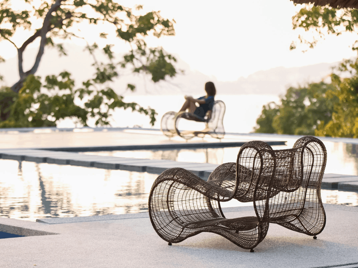 Eleganter Pigalle Designer-Sessel von Kenneth Cobonpue mit geschwungener Rückenlehne und filigranem Korbgeflecht.