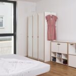 Tojo Stehschrank aus hellem Holz mit minimalistischem Design für moderne Einrichtung.