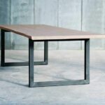 Moderner Esstisch mit schwarzem Röhrengestell und Holzplatte von Heerenhuis.