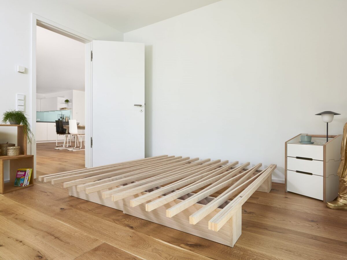 Minimalistisches Tojo V Bett aus Holz mit innovativem modularem Stecksystem für flexible Raumgestaltung.