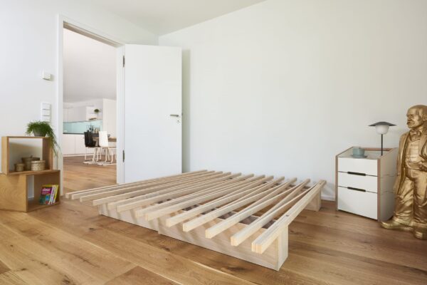 Minimalistisches Tojo V Bett aus Holz mit innovativem modularem Stecksystem für flexible Raumgestaltung.