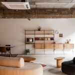 Modernes String Regalsystem mit Büchern und Dekorationsobjekten im skandinavischen Wohnzimmer-Design.