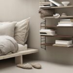 Modernes Schlafzimmer mit String Furniture Regalsystem und minimalistischer Einrichtung.